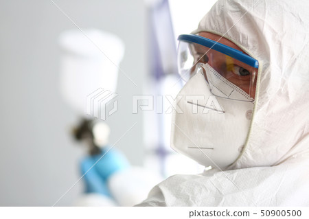 Man with pulverizer in hands look in camera thru protective glasses Man with pulverizer in hands look in camera thru protective glasses 50900500