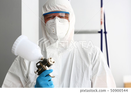 Workman hold in arm airbrush gun wearing protective suit 50900544