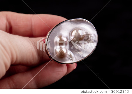 A silver ring with three pearls under a nacre A silver ring with three pearls under a nacre 50912543