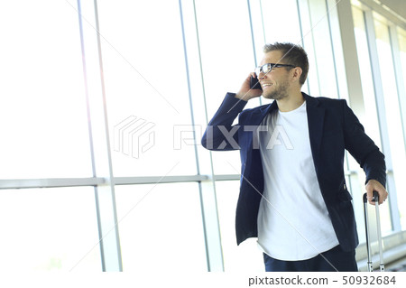 Businessman on the phone at the airport Businessman on the phone at the airport 50932684