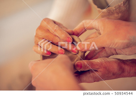 Close up of female hands molding a bowl 50934544