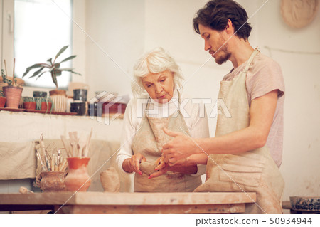 Pleasant young man asking a question to the teacher 50934944