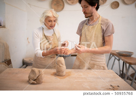 Serious creative man and woman making pots Serious creative man and woman making pots 50935768