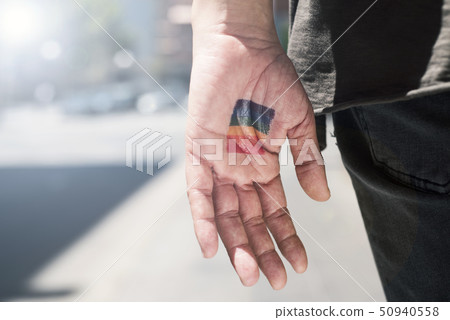person with a rainbow flag in his or her hand. 50940558