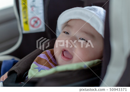 Baby sitting on a child seat 50943371