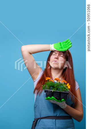 Photo of tired brunette girl with marigolds in her hands Photo of tired brunette girl with marigolds in her hands 50951066