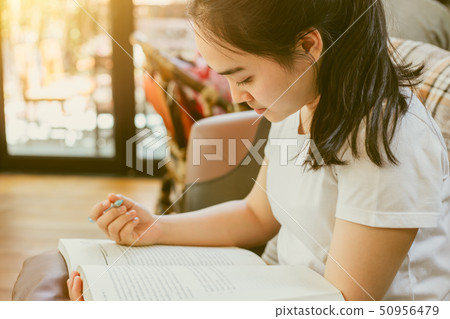 Cute Asian young girl teen doing homework paper Cute Asian young girl teen doing homework paper 50956479