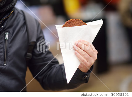 Man holding traditional dutch food - waffles Man holding traditional dutch food - waffles 50958391