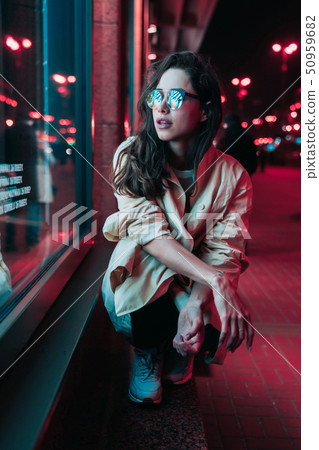 Night in the city, beautiful woman among red lights. 50959682