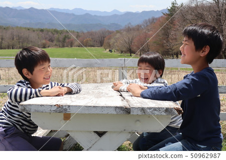 A child sitting on a bench and talking 50962987
