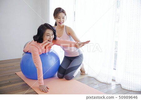 Healthy family concept, mother and daughter are doing exercise. 079 50989646