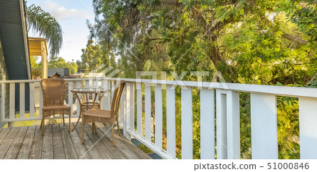 Wicker furniture on balcony overlooking lush trees Wicker furniture on balcony overlooking lush trees 51000846
