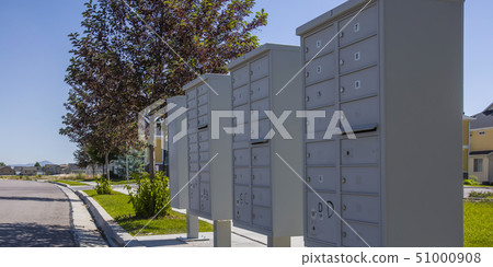 White mailboxes on a sunny landscaped sidewalk White mailboxes on a sunny landscaped sidewalk 51000908