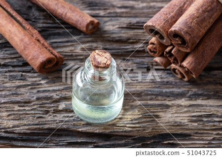 A bottle of cinnamon essential oil with cinnamon 51043725