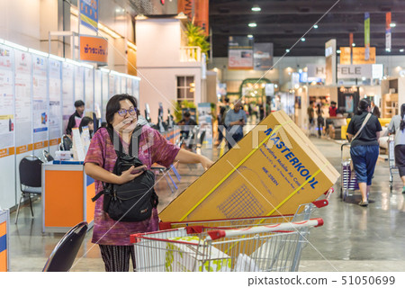 Asian woman with shopping cart in department store Asian woman with shopping cart in department store 51050699