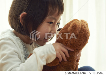 女孩坐在地板上和玩一隻小熊 51054582