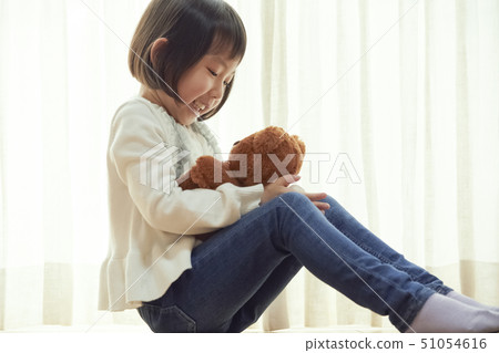 女孩坐在地板上和玩一隻小熊 51054616