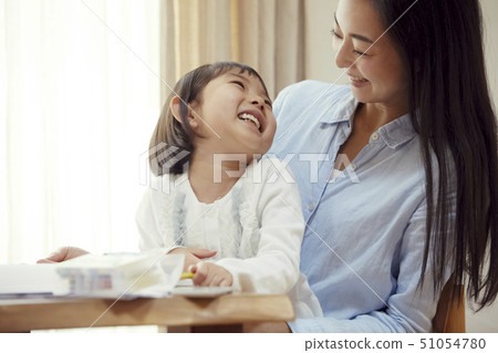 Daughter riding on mother's lap and drawing Daughter riding on mother's lap and drawing 51054780