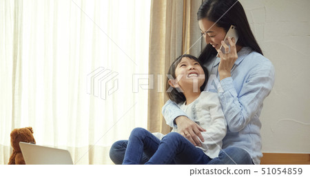 女兒抱著媽媽的膝蓋在地板上 51054859