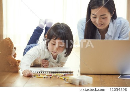 母親和女兒休息說謊在客廳的地板上 母親和女兒休息說謊在客廳的地板上 51054898