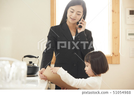 顯示寫生簿的女兒對電話的母親在廚房裡 51054988