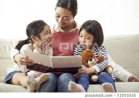 有老師的孩子在沙發上看書和聽 51055038