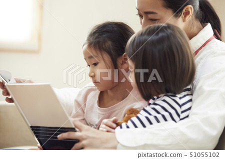 有老師的孩子在沙發上看書和聽 51055102