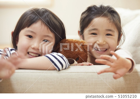 Children putting their necks on the couch's armrest 51055210
