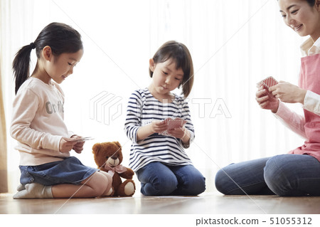 老師和孩子坐在地板上和玩紙牌 51055312