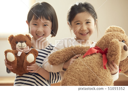 Kids holding big bear and small bear looking at camera Kids holding big bear and small bear looking at camera 51055352