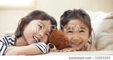孩子們把他們的脖子放在沙發的扶手上 孩子們把他們的脖子放在沙發的扶手上 51055354