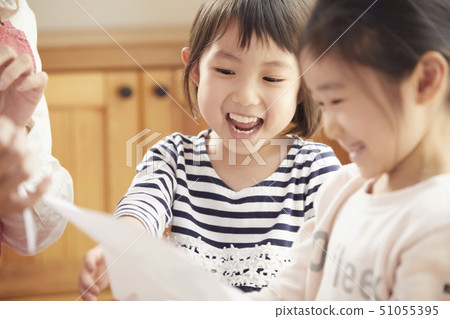 A teacher who takes a problem sitting on the floor and children answering it A teacher who takes a problem sitting on the floor and children answering it 51055395