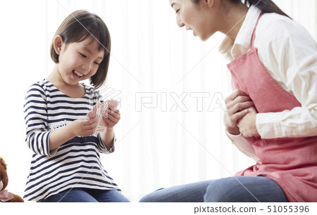 Teacher and children sitting on the floor and playing cards 51055396