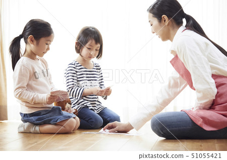 老師和孩子坐在地板上和玩紙牌 51055421