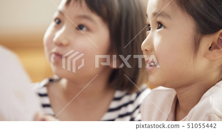 A teacher who takes a problem sitting on the floor and children answering it 51055442