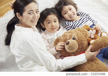 Mother and daughter lying on bed 51055496