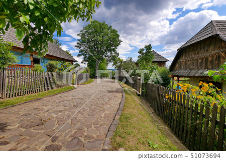 A winding street in a village with a paved stone p 51073694