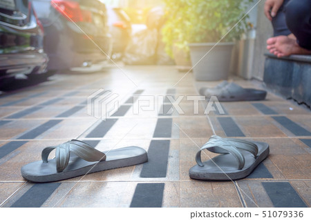 Sandals on the sidewalk behind the parking lot 51079336