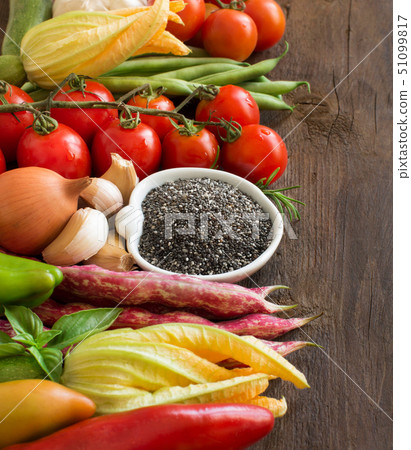 Raw chia seeds in bowl and vegetables 51099817