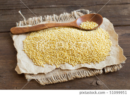 Raw millet with a spoon 51099951