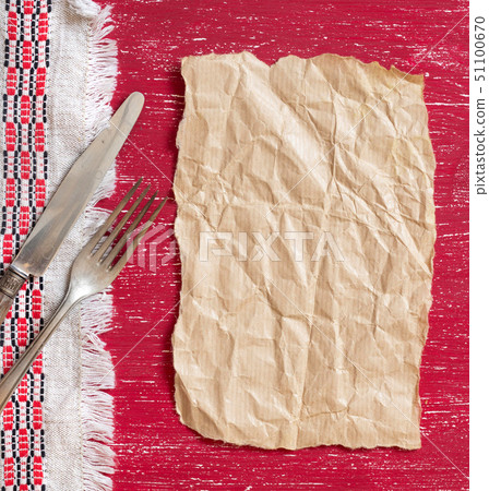 Vintage fork and knife on napkin on red wood and 51100670