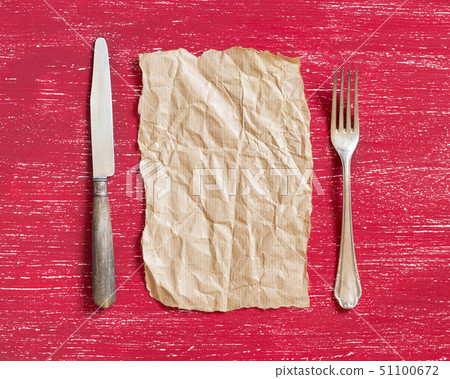 Vintage fork and knife with craft paper on red 51100672