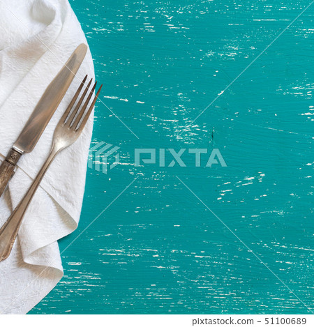 Vintage fork and knife on napkin on turquoise wood 51100689
