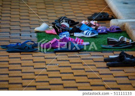 Several pairs of flip-flops next to open pool in winter Several pairs of flip-flops next to open pool in winter 51111133