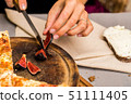 Close up female hands cutting fig with knife 51111405