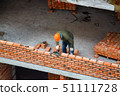 View of mason laying bricks at construction site 51111728