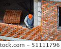 View of mason laying bricks at construction site 51111796