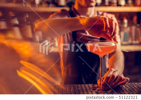 Close up of barman finishing making cocktail for client Close up of barman finishing making cocktail for client 51122321
