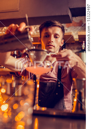 Barman wearing balk apron making cocktail with juice Barman wearing balk apron making cocktail with juice 51122497