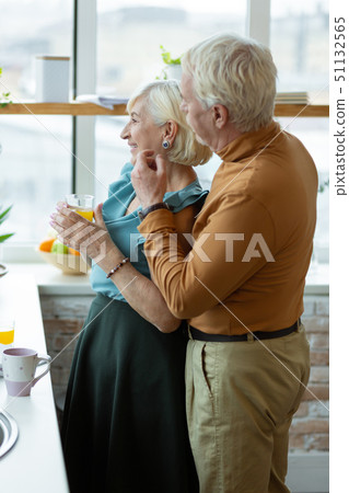 Full-sized shot of man hugging his wife at the kitchen Full-sized shot of man hugging his wife at the kitchen 51132565